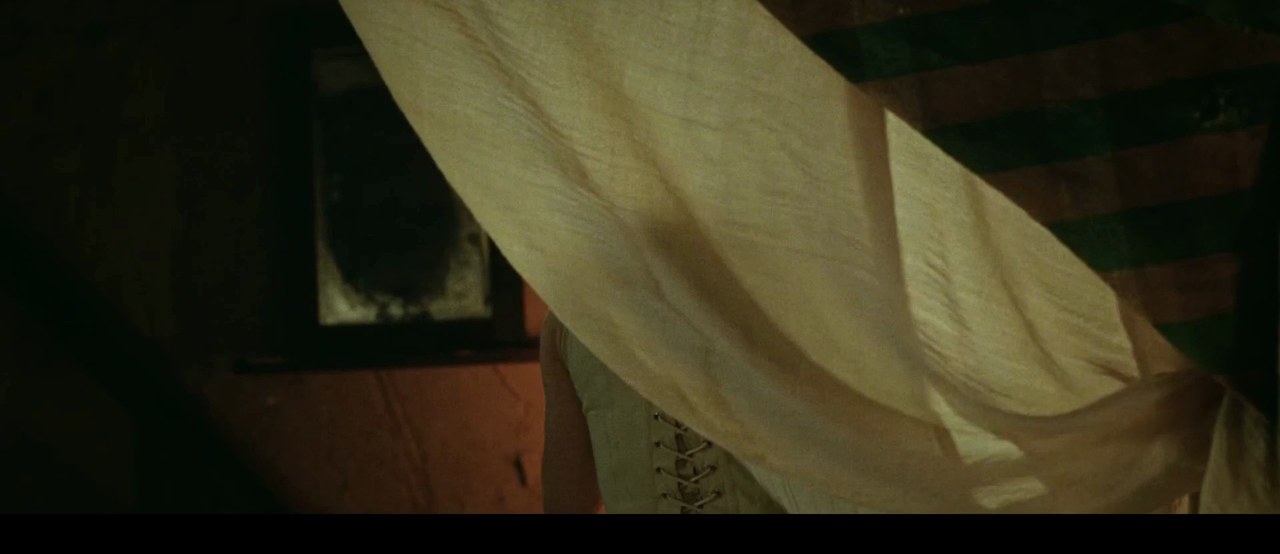 Amanda Seyfried as Ann Lee by the curtained bed, The Testament of Ann Lee (2025)