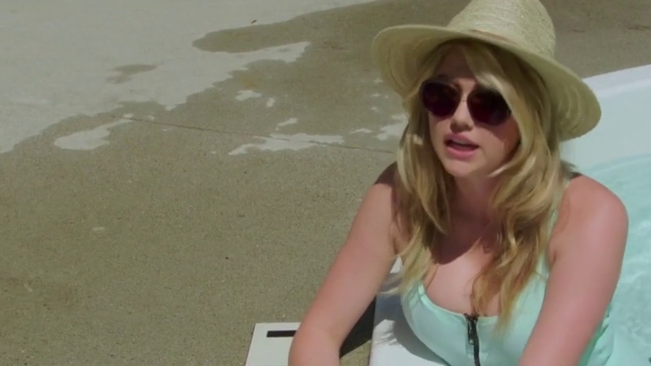 Kate Upton as Meg in a sun hat and sunglasses by the pool in The Layover (2017)