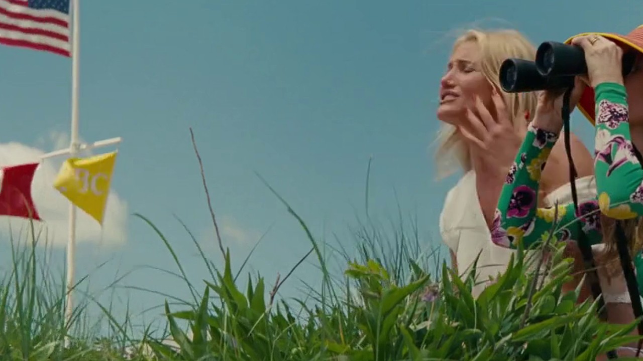 Kate Upton as Amber on the beach in a white bikini, watched by Leslie Mann, in The Other Woman (2014)