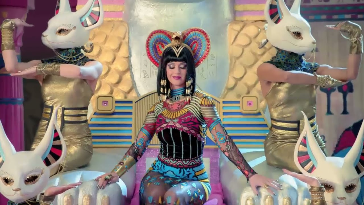 Katy Perry as Katy Patra between the cat-headed guards in the Dark Horse video (2014)